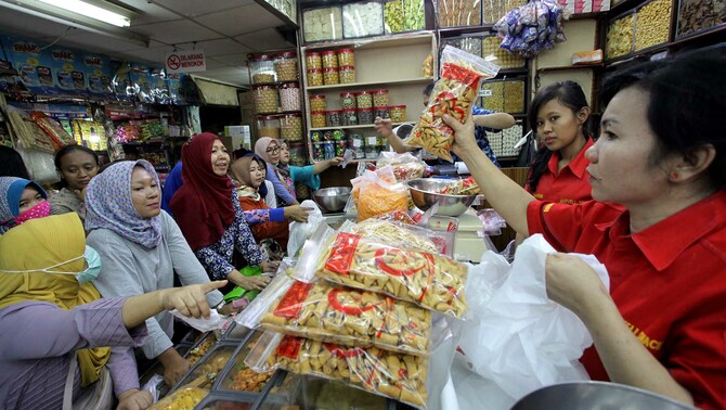 Pengunjung antre untuk membeli kue kering di sebuah toko di Pasar Jatinegara, Selasa 13 Juni 2018.