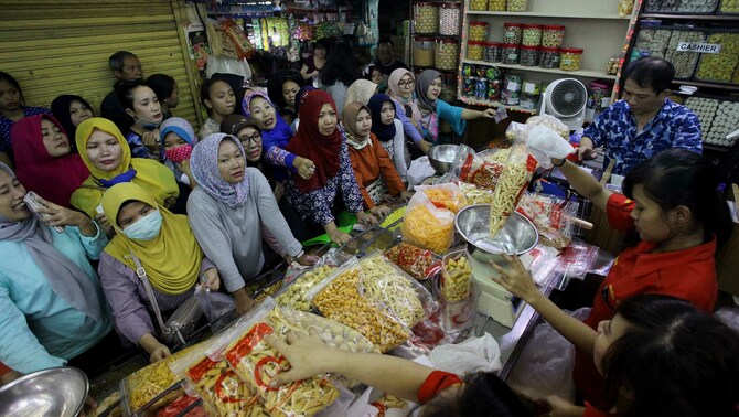 Pengunjung antre untuk membeli kue kering di sebuah toko di Pasar Jatinegara, Selasa 13 Juni 2018.