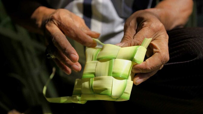 Pedagang membuat cangkang ketupat di Pasar Jatinegara, Jakarta, 13 Juni 2018.