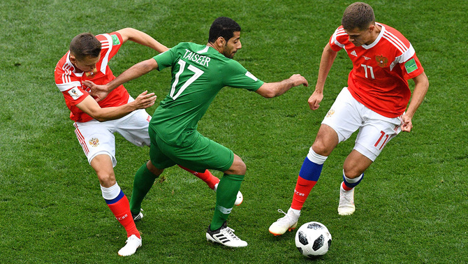 Gelandang Timnas Arab Saudi, Taisir Al-Jassim (tengah) dibayangi dua pemain Timnas Rusia dalam laga pembukaan Piala Dunia 2018 Grup A di Stadion Luzhniki, Rusia, 14 Juni 2018.