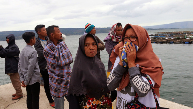 Seorang wanita mencium baju anaknya, penumpang KM Sinar Bangun, yang tenggelam di Danau Toba, Simalungun, Sumatra Utara, 19 Juni 2018. Para keluarga penumpang KM Sinar Bangun mulai mendatangi posko di Pelabuhan Tigaras, Danau Toba, untuk mencari informasi tentang anggota keluarga mereka.