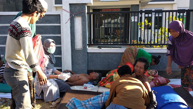 Warga korban gempa mendapatkan perawatan di luar Puskesmas Sembalun Selong, Lombok Timur, NTB, 29 Juli 2018.
