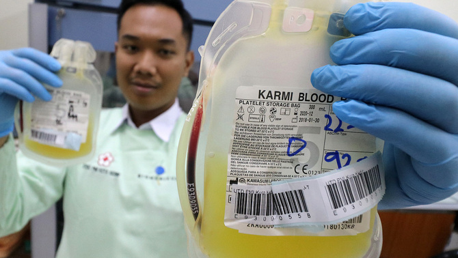 Petugas unit transfusi darah Palang Merah Indonesia (PMI) juga menambah stok darah trombosit untuk mengantisipasi kebutuhan darah yang terus meningkat karena maraknya kasus Demam Berdarah Dengue (DBD). Petugas PMI memperlihatkan kantung berisi darah trombosit di PMI Kota Kediri, Jawa Timur, 22 Januari 2019. PMI daerah setempat menambah produksi darah trombosit hingga sepuluh kantung per hari dari normalnya lima kantung per hari karena permintaan yang meningkat akibat wabah demam berdarah dengue.