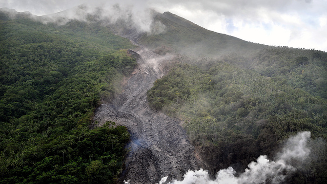 Material vulkanik gunung api Karangetang terpantau dari laut bagian barat Pulau Siau, Kabupaten Kepulauan Sitaro, Sulawesi Utara, 7 Februari 2019. Gunung tersebut masih mengeluarkan kepulan asap putih serta muntahan material vulkanik berupa lahar, batuan serta pasir sejauh 3.500 meter dan telah mencapai garis pantai.