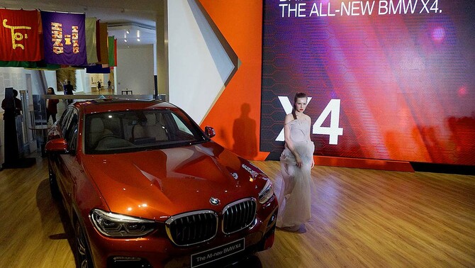 Model berpose di depan mobil The All New BMW X4 dalam peluncuran di Jakarta, 7 Februari 2019.