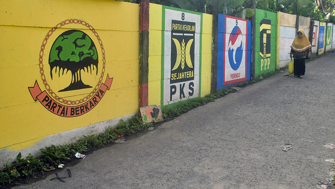 PEMILU DAMAI - Warga melintas di depan mural bergambar partai politik peserta Pemilu 2019 di Kelurahan Gunung Batu, Kota Bogor, Jawa Barat, 3 Februari 2019. Mural yang dibuat secara swadaya oleh warga di wilayah tersebut sekaligus untuk mensosialisasikan gambar partai politik peserta Pemilu 2019 kepada masyarakat.