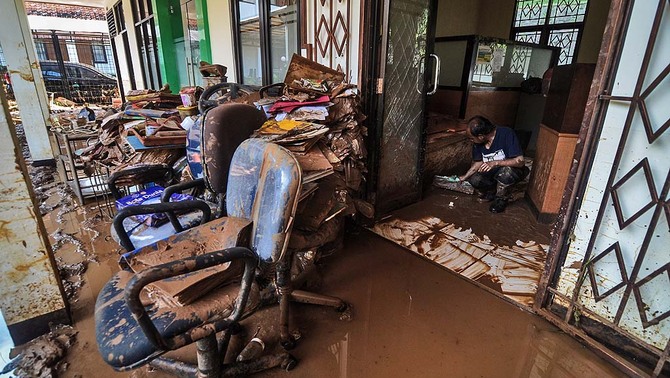 Petugas membersihkan lumpur pascabanjir bandang yang melanda Kantor Balai Penelitian Tanaman Pangan (BPTP) di Pasir Jati, Cilengkrang, Kabupaten Bandung, Jawa Barat, 11 Februari 2019. Ketua Badan Pengurus Forum Komunikasi Kader Konservasi Indonesia (BP FK3I), Dedi Kurniawan mengatakan, banjir bandang yang terjadi di Pasir Jati tersebut diduga akibat alih fungsi lahan dari kawasan serapan menjadi kawasan non-resapan di Kawasan Bandung Utara (KBU).