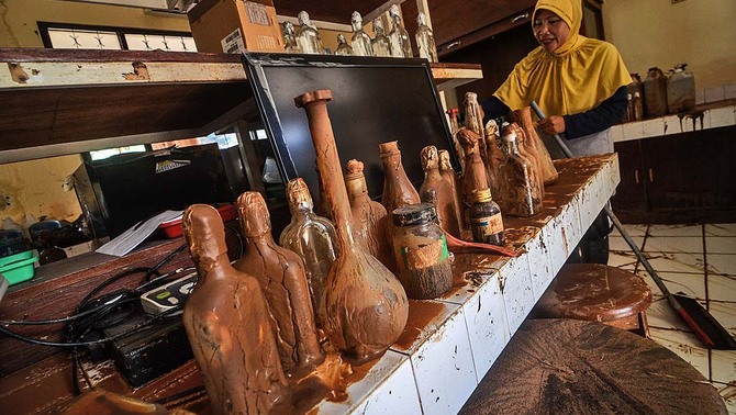 Petugas membersihkan alat penelitian pascabanjir bandang yang melanda Kantor Balai Penelitian Tanaman Pangan (BPTP) di Pasir Jati, Cilengkrang, Kabupaten Bandung, Jawa Barat, 11 Februari 2019. Ketua Badan Pengurus Forum Komunikasi Kader Konservasi Indonesia (BP FK3I), Dedi Kurniawan mengatakan, banjir bandang yang terjadi di Pasir Jati tersebut diduga akibat alih fungsi lahan dari kawasan serapan menjadi kawasan non-resapan di Kawasan Bandung Utara (KBU).
