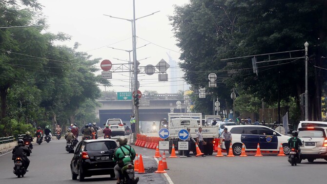 Sejumlah kendaraan melintasi papan penunjuk arah saat uji coba sistem satu arah di Dukuh Bawah, Jakarta Selatan, Selasa 12 Februari 2019.