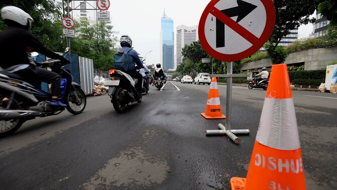 Sejumlah kendaraan melintasi papan penunjuk arah saat uji coba sistem satu arah di Dukuh Bawah, Jakarta Selatan, Selasa 12 Februari 2019.