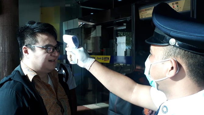 Petugas Keamanan PT Bank Tabungan Negara (Persero) Tbk. sedang mengukur suhu para karyawan dan pengunjung yang akan masuk ke dalam lingkungan kerja perseroan, di Jakarta, Selasa (10/3/2020). 