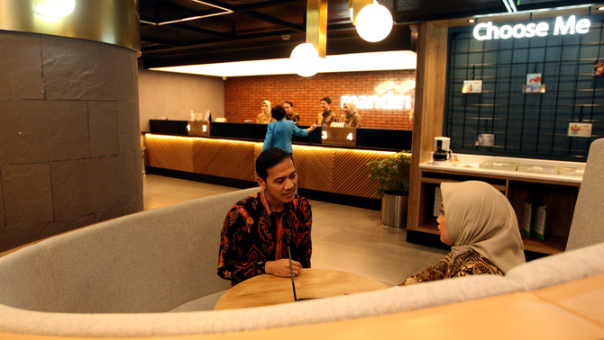 Nasabah berbincang dengan petugas bank disela-sela peresmian kantor di Mal Senayan City, Jakarta, Rabu (11/3/2020). Bank Mandiri mendesain ulang kantor cabang di kawasan pusat belanja tersebut dengan konsep kekinian dan berorientasi pada edukasi digital untuk mengantisipasi maraknya penggunaan transaksi digital oleh nasabah.