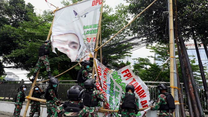 Prajurit TNI menertibkan spanduk tidak berizin saat patroli keamanan kawasan Petamburan, Jakarta Pusat, Jumat 20 November 2020.