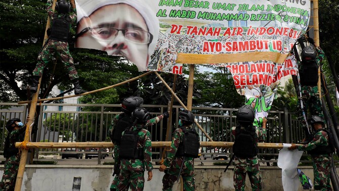 Prajurit TNI menertibkan spanduk tidak berizin saat patroli keamanan kawasan Petamburan, Jakarta Pusat, Jumat 20 November 2020.