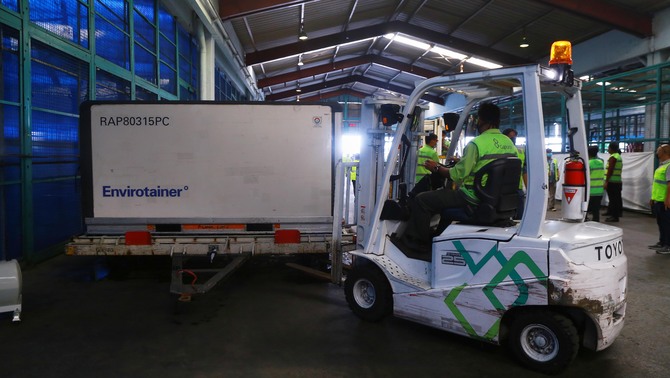 Petugas memindahkan paket vaksin Covid-19 di Terminal Kargo Bandara Soekarno-Hatta, Tangerang, Banten, Kamis 31 Desember 2020. Pemerintah dalam waktu dekat akan mendistribusikan vaksin Covid-19 ke 34 provinsi.