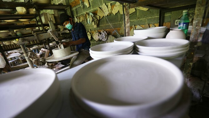 Keramikus melakukan tramming atau merapihkan bentuk kerajinan keramik di Pekunden Pottery, Bojongsari, Depok, Jawa Barat, Kamis, 23 September 2021. Produksi keramik rumahan berbahan tanah liat bakaran tinggi tersebut dijual dengan harga Rp50 ribu hingga Rp3 juta per buah tergantung ukuran dan tingkat kesulitan. 