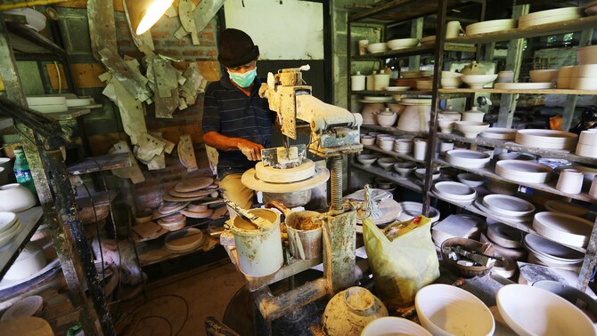 Keramikus melakukan tramming atau merapihkan bentuk kerajinan keramik di Pekunden Pottery, Bojongsari, Depok, Jawa Barat, Kamis, 23 September 2021. Produksi keramik rumahan berbahan tanah liat bakaran tinggi tersebut dijual dengan harga Rp50 ribu hingga Rp3 juta per buah tergantung ukuran dan tingkat kesulitan. 