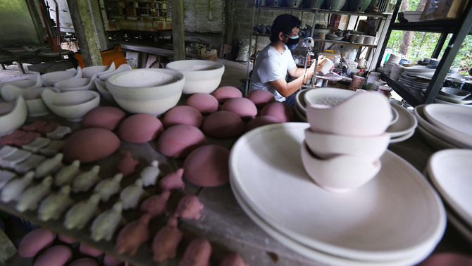 Keramikus melakukan sgraffito atau proses aplikasi corak pada kerajinan keramik di Pekunden Pottery, Bojongsari, Depok, Jawa Barat, Kamis, 23 September 2021.  Produksi keramik rumahan berbahan tanah liat bakaran tinggi tersebut dijual dengan harga Rp50 ribu hingga Rp3 juta per buah tergantung ukuran dan tingkat kesulitan. 