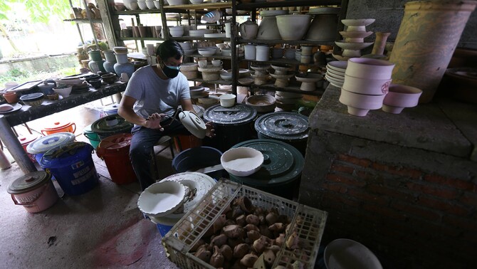 Keramikus melakukan sgraffito atau proses aplikasi corak pada kerajinan keramik di Pekunden Pottery, Bojongsari, Depok, Jawa Barat, Kamis, 23 September 2021.  Produksi keramik rumahan berbahan tanah liat bakaran tinggi tersebut dijual dengan harga Rp50 ribu hingga Rp3 juta per buah tergantung ukuran dan tingkat kesulitan. 