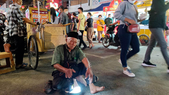 Pengemis di Tangerang, Banten, Jumat, 25 Februari 2022. Berbagai jajanan dijual, di Jalan yang ditetepakan  menjadi kawasan Culinary Night Kota Tangerang  pada 2014 silam itu seperti tak mengenal pemberlakuan pembatasan aktivitas manusia terkait penyebaran virus Corona. 