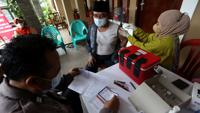Tenaga kesehatan memberikan vaksin booster jenis AstraZeneca kepada warga di Perumahan Vila Pamulang, Pondok Petir, Bojongsari, Depok, Jawa Barat, Sabtu, 26 Maret 2022. Sebanyak 200 dosis vaksin booster jenis AstraZeneca diberikan untuk warga selain vaksin Sinovc untuk vaksin pertama dan kedua.