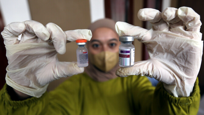 Tenaga kesehatan memperlihatkan dosis vaksin Covid-19 di Perumahan Vila Pamulang, Pondok Petir, Bojongsari, Depok, Jawa Barat, Sabtu, 26 Maret 2022. Sebanyak 200 dosis vaksin booster jenis AstraZeneca diberikan untuk warga selain vaksin Sinovc untuk vaksin pertama dan kedua.