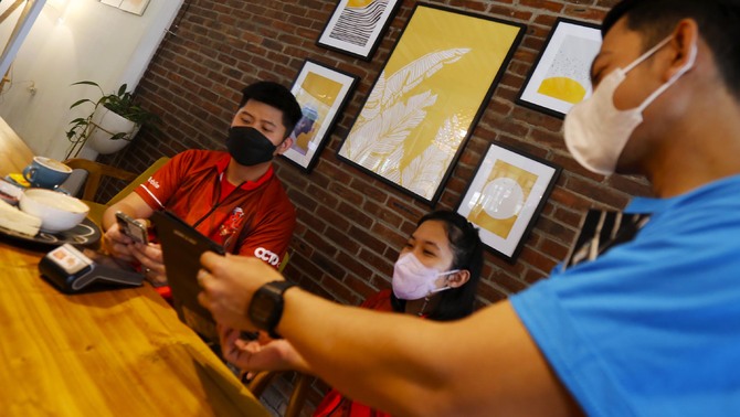 Nasabah melakukan pembayaran menggunakan scan Qris OCTO Mobile Bank CIMB Niaga di Tangerang Selatan, Sabtu, 26 Maret 2022.
