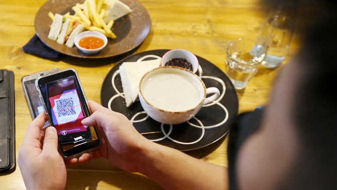 Nasabah melakukan pembayaran menggunakan scan Qris OCTO Mobile Bank CIMB Niaga di Tangerang Selatan, Sabtu, 26 Maret 2022.