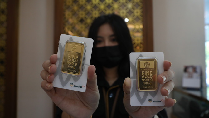 Karyawati menunjukkan emas batangan yang dijual di Galeri 24 Pegadaian, Jakarta.