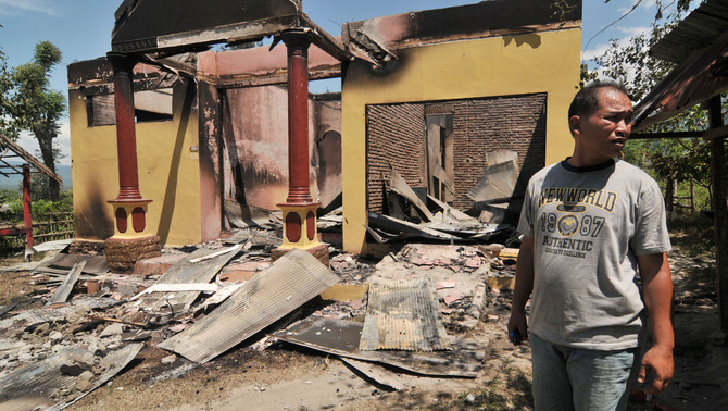 Seorang warga berdiri di antara puing-puing rumah yang telah dibakar saat bentrok antar warga Desa Binangga dan Padende di Kecamatan Marawola, Kab. Sigi, Sulawesi Tengah. FOTO: ANTARA/Basri Marzuki