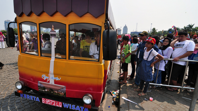 Warga mengantre naik kereta wisata di kawasan Monas, Jakarta Pusat. FOTO: ANTARA/Dian Dwi Saputra/