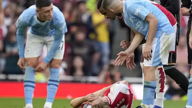 Pemain Arsenal Martin Odegaard terbaring di lapangan dalam pertandingan Liga Inggris melawan Manchester City di Stadion Emirates, London, Minggu, 8 Oktober 2023.
