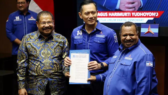 Ketua Umum Partai Demokrat Agus Harimurti Yudhoyono AHY (tengah) menyerahkan surat rekomendasi Bakal Calon Gubernur Papua Pegunungan John Tabo (kiri) dan Bakal Calon Wakil Gubernur Ones Pahabol (kanan) untuk Pilkada 2024 di Kantor DPP Demokrat, Jakarta, Jumat 19 Juli 2024.