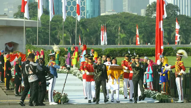 Tim Purna Paskibraka 2023 Kachina Ozora (tengah depan) membawa duplikat bendera Merah Putih sementara rekannya Keyla Azzahra Purnama (tengah belakang) membawa naskah teks proklamasi berjalan menuju kendaraan taktis maung dalam acara kirab bendera Merah Putih dan naskah teks proklamasi menuju Ibu Kota Nusantara (IKN) di kawasan Monumen Nasional (Monas), Jakarta, Sabtu 10 Agustus 2024.