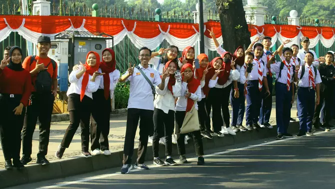 Warga dan pelajar saat menyaksikan kirab duplikat bendera pusaka Merah Putih dan naskah teks Proklamasi melintas di Jalan Medan Merdeka Barat, Jakarta, Sabtu 10 Agustus 2024.