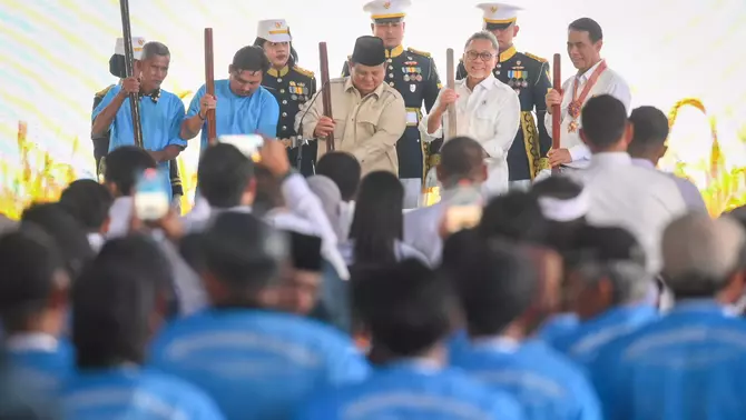 Presiden Prabowo Subianto (tengah) didampingi Menteri Koordinator Bidang Pangan Zulkifli Hasan (kedua kanan) dan Menteri Pertanian Amran Sulaiman (kanan) menumbukkan alu pada lesung dalam acara panen raya dan pengumuman swasembada pangan nasional 2025 di Cilebar, Karawang, Jawa Barat, Rabu 7 Januari 2026.