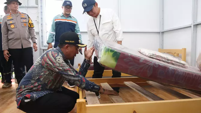 Bupati Pidie Jaya Sibral Malasyi (jongkok) mengecek fasilitas hunian sementara (huntara) yang dibangun Danantara di Meureudu, Pidie Jaya, Aceh, Sabtu, 14 Februari 2026.