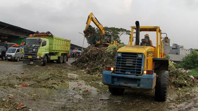 Petugas menggunakan alat berat mengangkut tumpukan sampah ke dalam truk, di Tempat Pembuangan Sementara (TPS) Pasar Induk Kramat Jati, Jakarta, Rabu 8 April 2026.