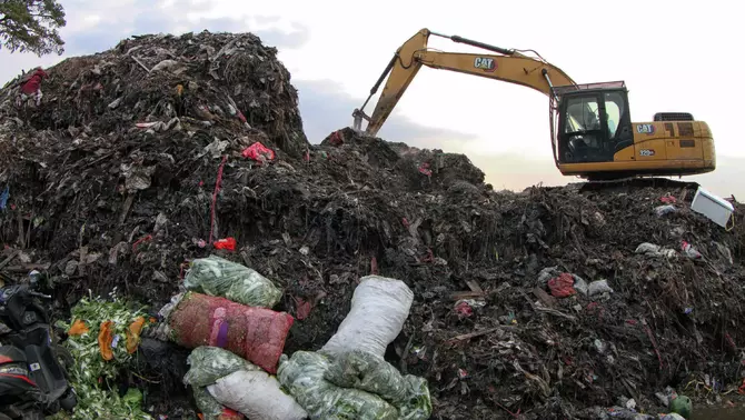 Petugas menggunakan alat berat mengangkut tumpukan sampah ke dalam truk, di Tempat Pembuangan Sementara (TPS) Pasar Induk Kramat Jati, Jakarta, Rabu 8 April 2026.