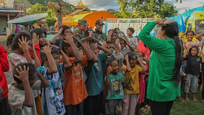 Anggota Persit Kartika Chandra Kirana menghibur anak-anak saat kegiatan pemulihan trauma di tempat pengungsian, Desa Terong, Flores Timur, Nusa Tenggara Timur, Sabtu 11 April 2026.