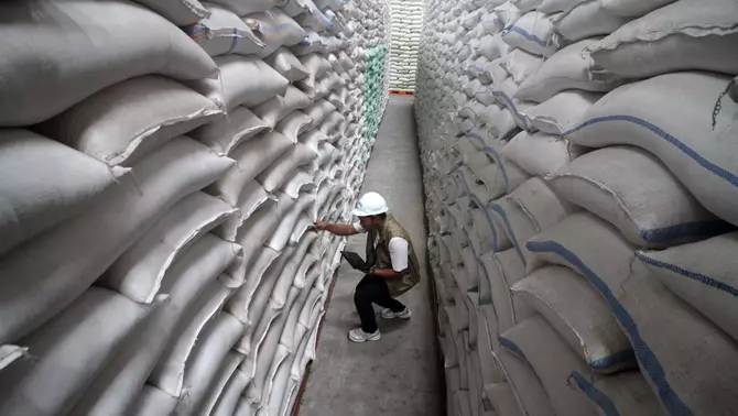 Petugas mengecek karung beras di gudang Bulog Divre Jatim, Buduran, Sidoarjo, Jawa Timur, Minggu 19 April 2026.