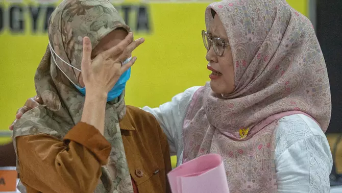 Komisioner Komisi Perlindungan Anak Indonesia (KPAI) Diyah Puspitarini (kanan) mendengarkan cerita dari orang tua korban saat konferensi pers pengungkapan kasus dugaan kekerasan dan penelantaran terhadap anak oleh Daycare Little Aresha di Mapolresta Yogyakarta, Yogyakarta, Senin 27 April 2026.