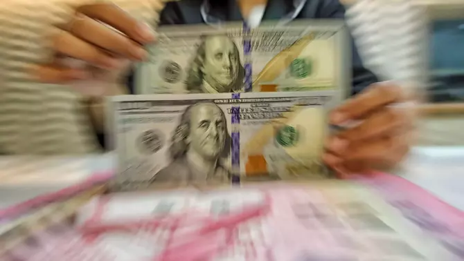 Petugas kasir menunjukkan uang pecahan dolar Amerika Serikat (AS) di gerai penukaran mata uang asing Ayu Masagung, Jakarta Pusat, Selasa 12 Mei 2026.