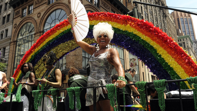Beberapa peserta berdiri diatas kendaraan hias  saat melakukan parade gay tahunan di New York, Amerika Serikat. FOTO:  AFP PHOTO/TIMOTHY A. CLARY