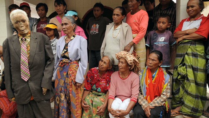 Anggota keluarga berdiri bersama jenazah Piter Sampe Sambara yang sudah meninggal 80 tahun lalu saat  ritual adat Ma'nene' di Gunung Sesean, Lembang Lempo Boton, Kec. Rinding Allo, Toraja Utara, Sulawesi Selatan. FOTO: ANTARA/Sahrul Manda Tiukupadang