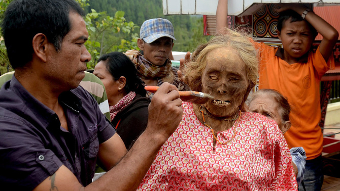 Anggota keluar membersihkan jenazah Martha Bu'tu' yang meninggal dunia 40 tahun lalu saat ritual adat Ma'nene' di Gunung Sesean, Lembang Lempo Boton, Kec. Rinding Allo, Toraja Utara, Sulawesi Selatan. FOTO:  EPA/ANDI SAMUDRA