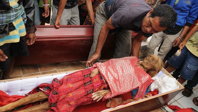 Sejumlah keluarga mengangkat jenazah alamarhum Nene' Martha Bu'tu' yang wafat 40 tahun lalu pada ritual adat Ma'nene' di Gunung Sesean, Lembang Lempo Boton, Kec. Rinding Allo, Toraja Utara, Sulsel. FOTO: ANTARA/Sahrul Manda Tiukupadang
