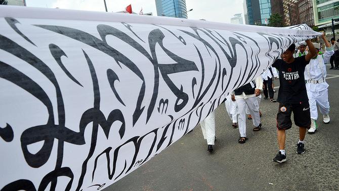 Ribuan masa yang tergabung dalam ormas Islam se-Indonesia melakukan pawai dengan membentangkan banner bertuliskan lafal Tauhid dan mengibarkan bendera di Jakarta, 16 Agustus 2015.