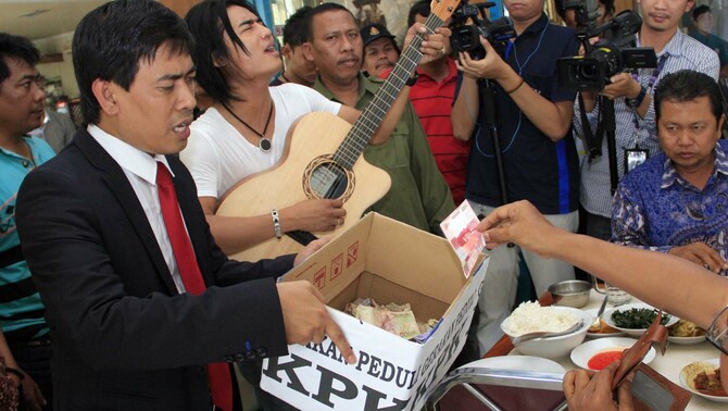 Musisi Charly Van Houten  bersama pengacara Ahmad Rifaimenggamen saat bergabung dalam gerakan peduli KPK di Kramat Sentiong, Jakarta. FOTO:  ANTARA/Agus Apriyanto