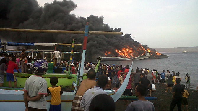 Sejumlah warga menyaksikan kapal siluman,  KRI Klewang  625 yang terbakar di dermaga Pangkalan TNI AL Banyuwangi, Jawa Timur. FOTO:  ANTARA